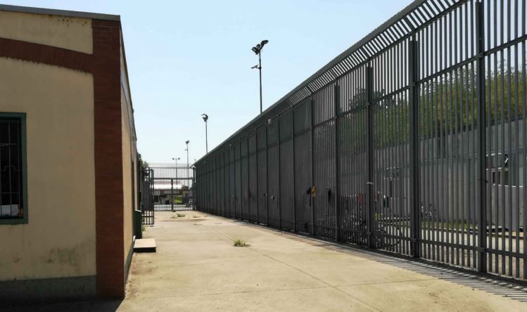 sbarre a destra, interno del cpr di Milano
