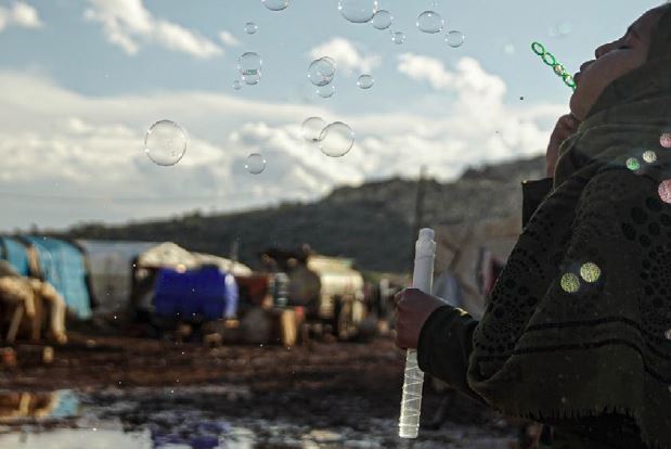 ragazza che soffia e fa le bolle in un villaggio